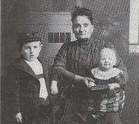 Anna Carstensen med barnebarnet, Carsten Friedrich Carstensen med kasket og et plejebarn.